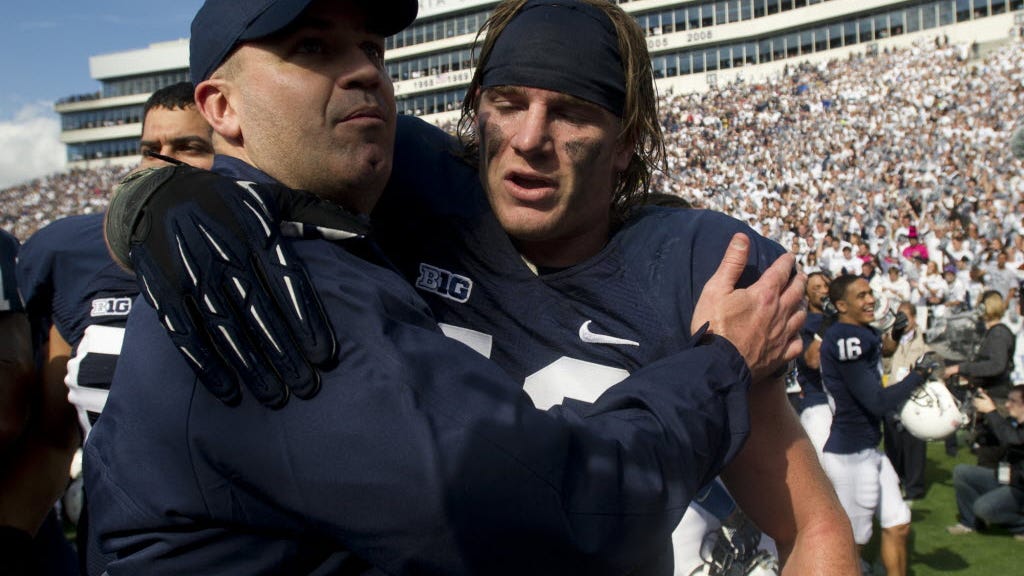 Penn State head coach Bill O'Brien, left, embraces Michael Mauti following his team's 39-28 victory over Northwestern on Oct. 6, 2012. Mauti, now with the Minnesota Vikings, is featured prominently in a new book about the 2011 Big Ten football season.