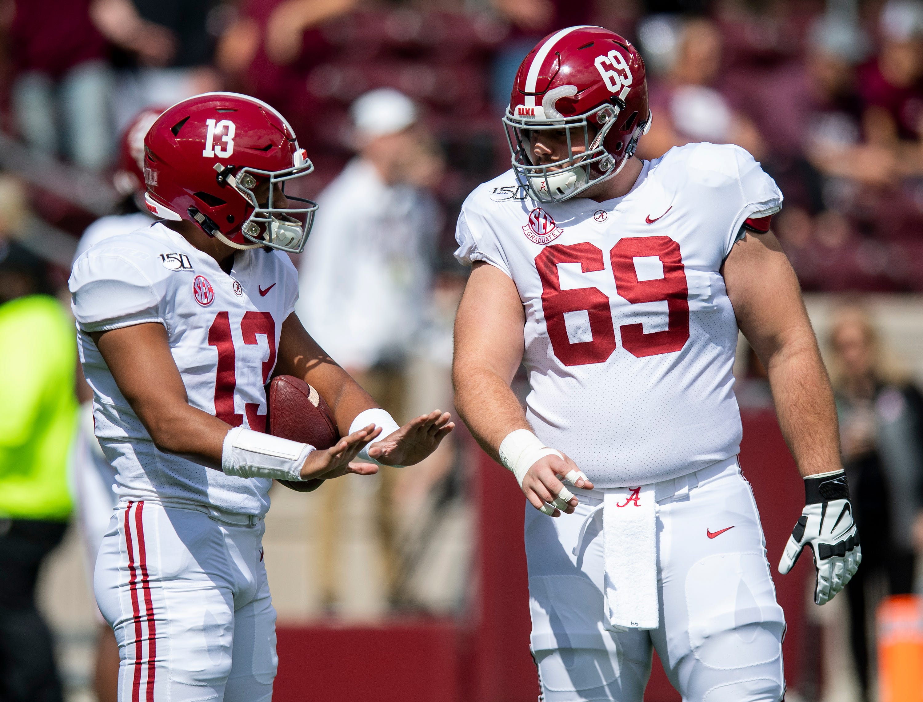 Alabama quarterback Tua Tagovailoa (13) talks with offensive lineman Landon Dickerson (69) before the Texas A&M game at Kyle Field in College Station, Texas on Saturday October 12, 2019.