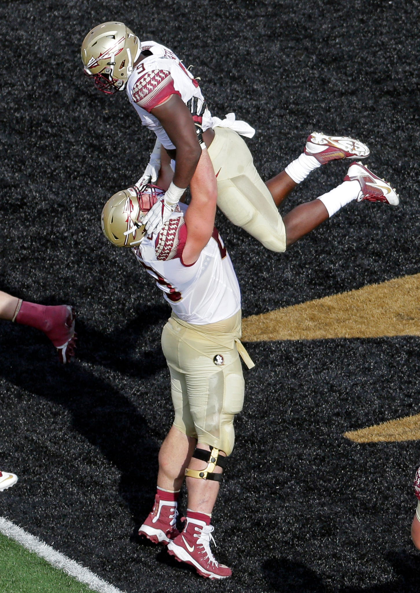 Florida State's Jacques Patrick (9) is lifted by Landon Dickerson (69) after his touchdown run against Wake Forest in the first half of an NCAA college football game in Winston-Salem, N.C., Saturday, Sept. 30, 2017. (AP Photo/Chuck Burton)