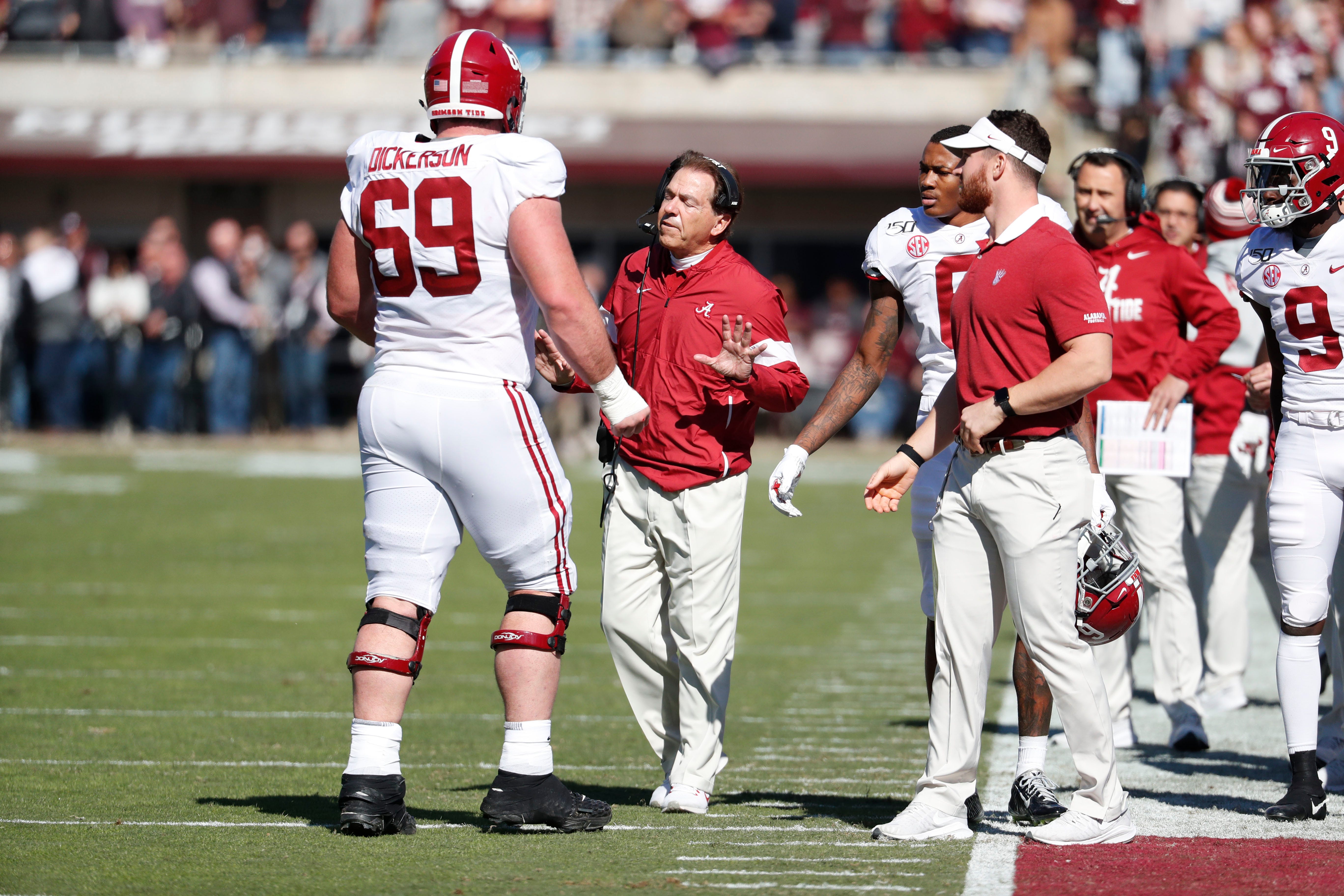 Alabama head coach Nick Saban confers with offensive lineman Landon Dickerson (69) during the first half of an NCAA college football game against Mississippi State in Starkville, Miss., Saturday, Nov. 16, 2019. Alabama won 38-7. (AP Photo/Rogelio V. Solis)