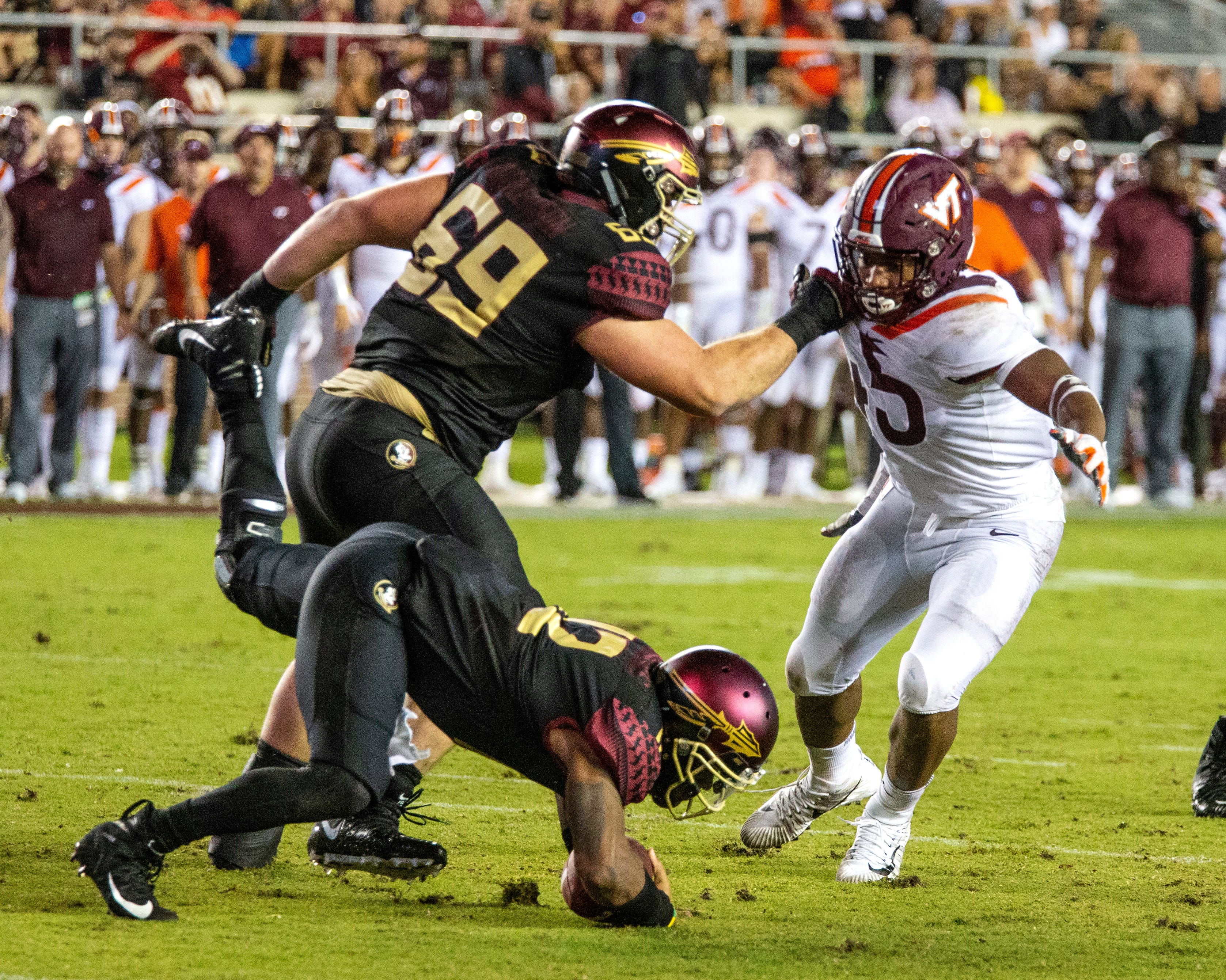 Florida State quarterback Deondre Francois (12) trips over Florida State offensive lineman Landon Dickerson (69) near his end zone in the second half of an NCAA college football game in Tallahassee, Fla., Monday, Sept. 3, 2018. Virginia Tech defeated Florida State 24-3. (AP Photo/Mark Wallheiser)